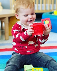 a toddler playing with blocks in a playroom